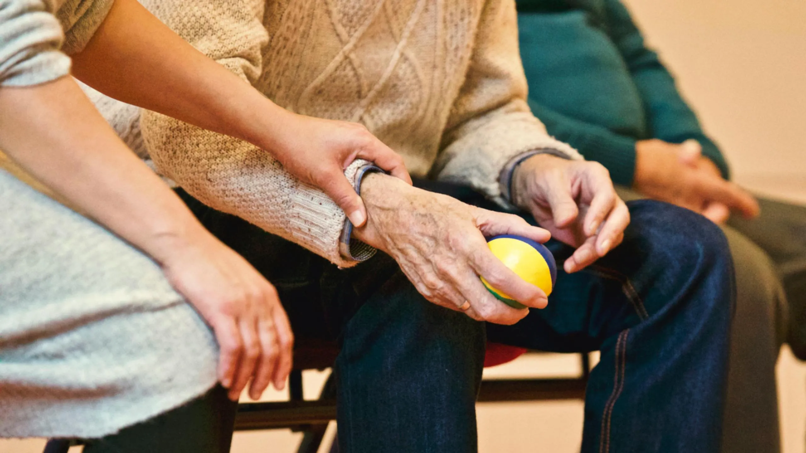 elderly female with arthritis holding therapy ball