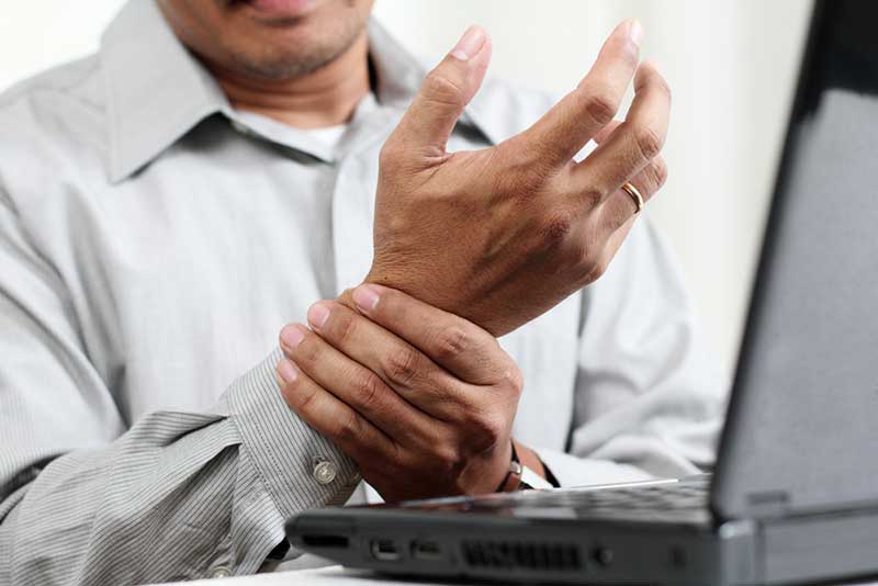man holding his hand in pain from arthritis
