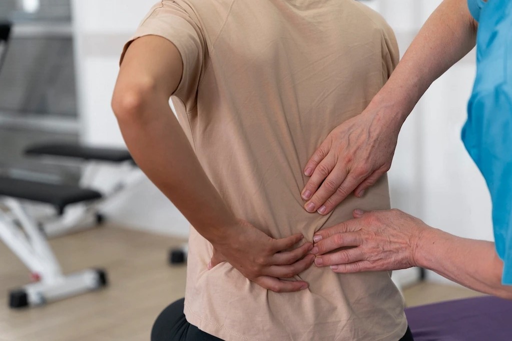 patient showing doctor where the pain hurts on her lower back