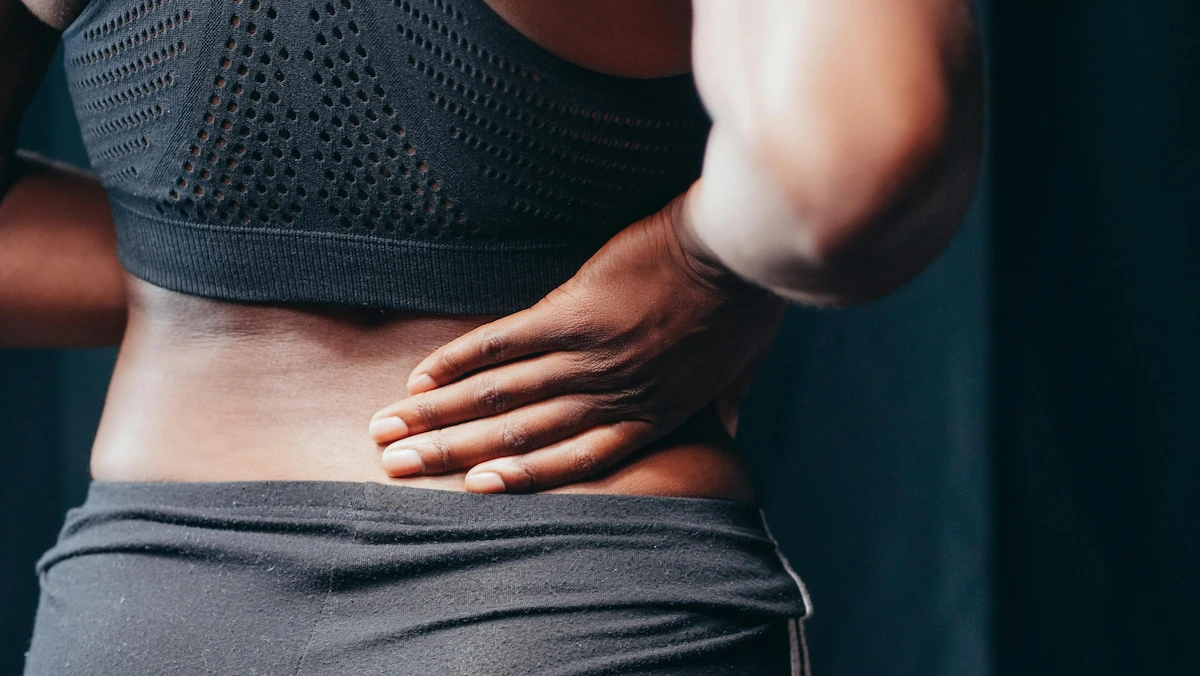 black female holding her low back in pain