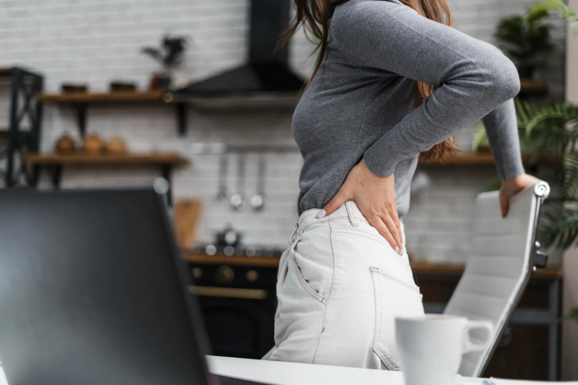 female holding her low back in pain